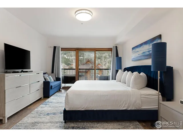 a bedroom with a bed tv and a window