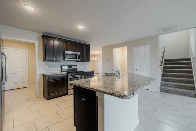 a kitchen with stainless steel appliances granite countertop a sink stove and refrigerator