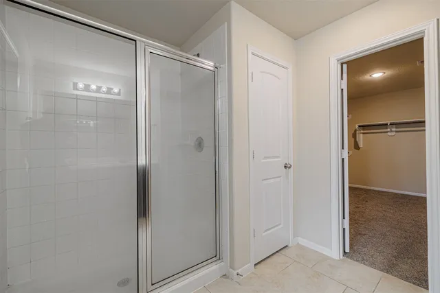a en suite bathroom with a double vanity sink a large mirror and a shower