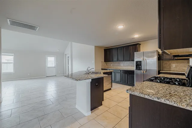 a large kitchen with a large counter top stainless steel appliances and cabinets