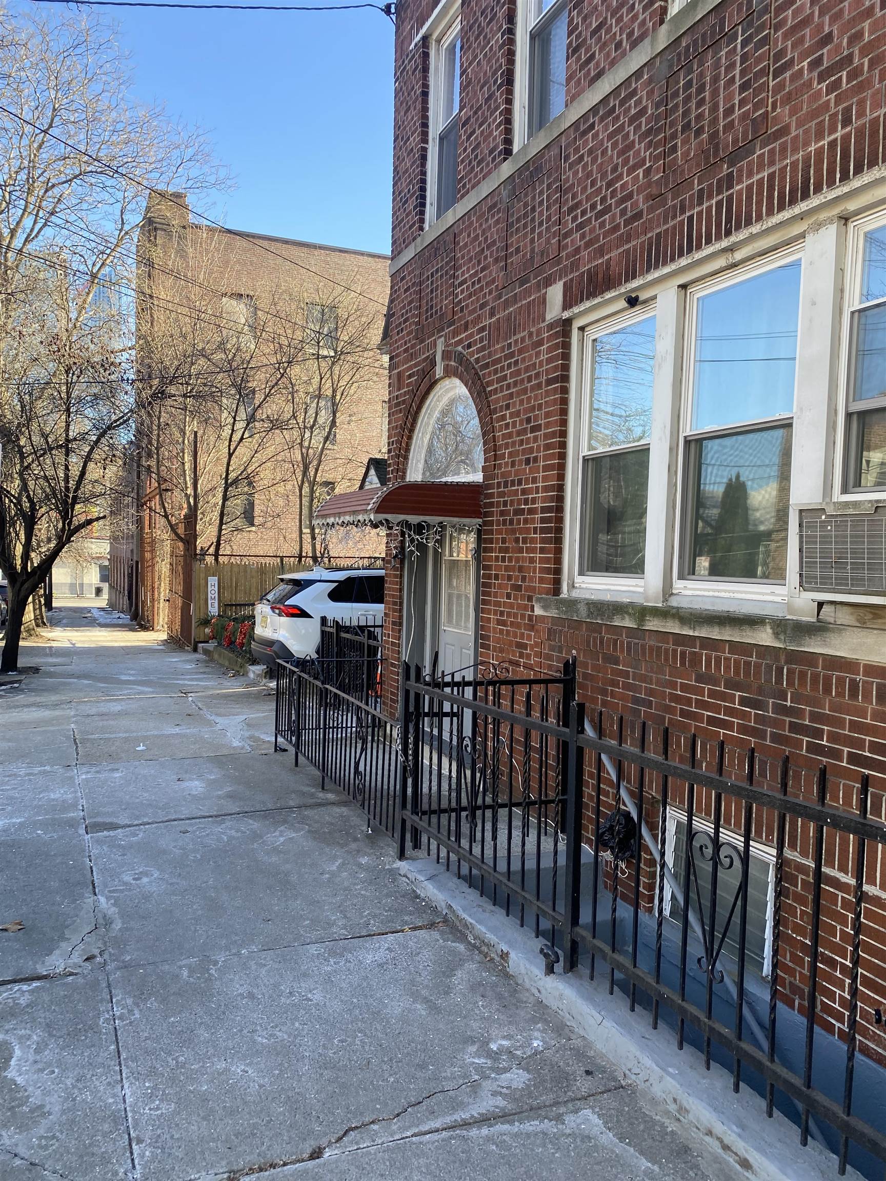 19 Fox Place, Unit 3 Jersey City, NJ 07306 - Photo 17 of 18 a view of a brick house with a bench and table and chairs under an umbrella