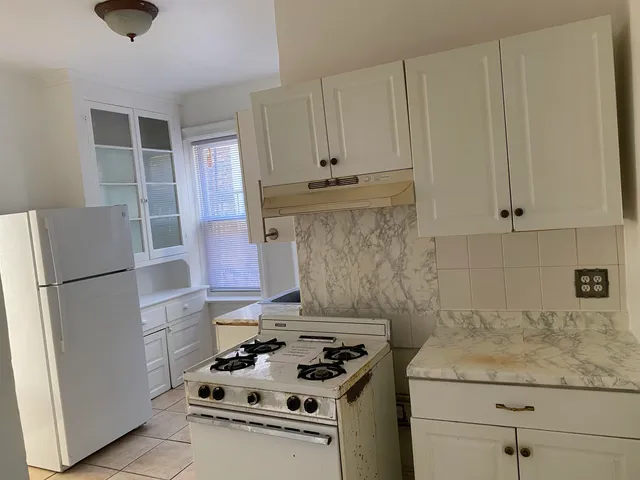 a kitchen with granite countertop a sink stove and refrigerator