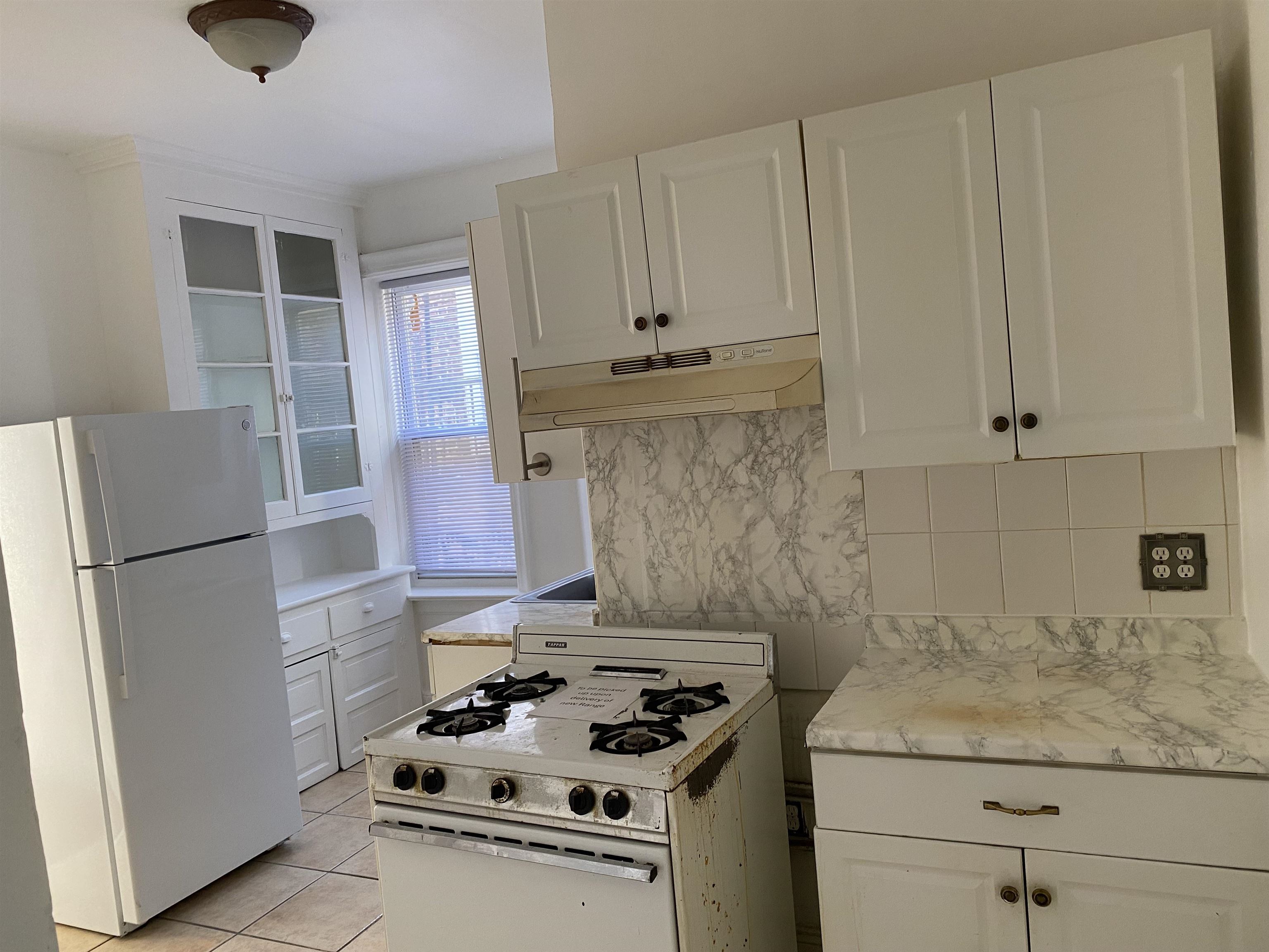 19 Fox Place, Unit 3 Jersey City, NJ 07306 - Photo 5 of 18 a kitchen with granite countertop a sink stove and refrigerator