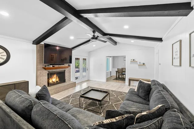 a living room with furniture a fireplace and a flat screen tv