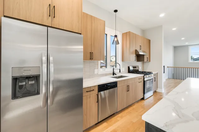 a large kitchen with a refrigerator a sink and a stove