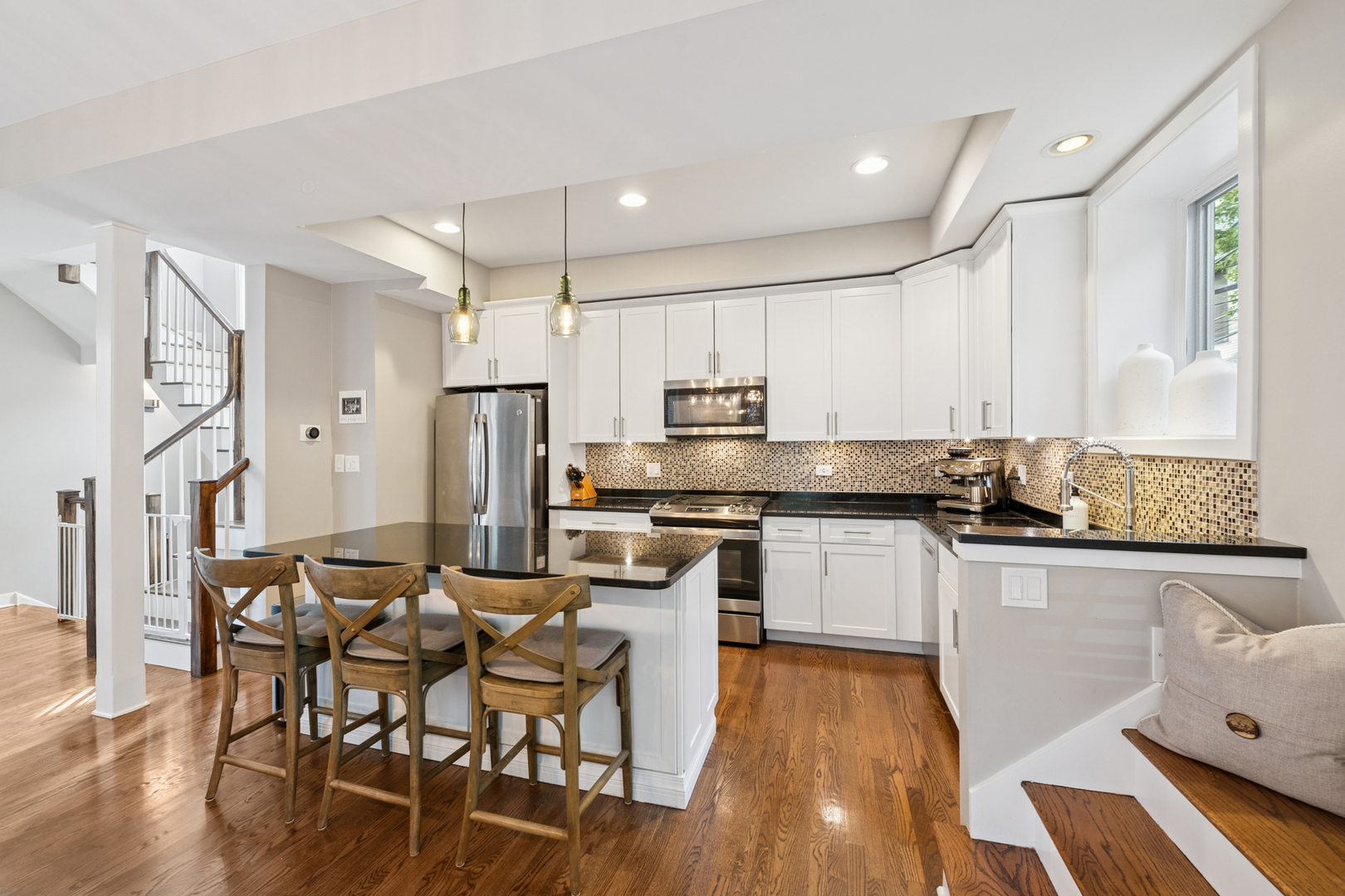 1809 West Melrose Street Chicago, IL 60657 - Photo 6 of 25 a kitchen with stainless steel appliances granite countertop a refrigerator a stove top oven a sink dishwasher and white cabinets with wooden floor