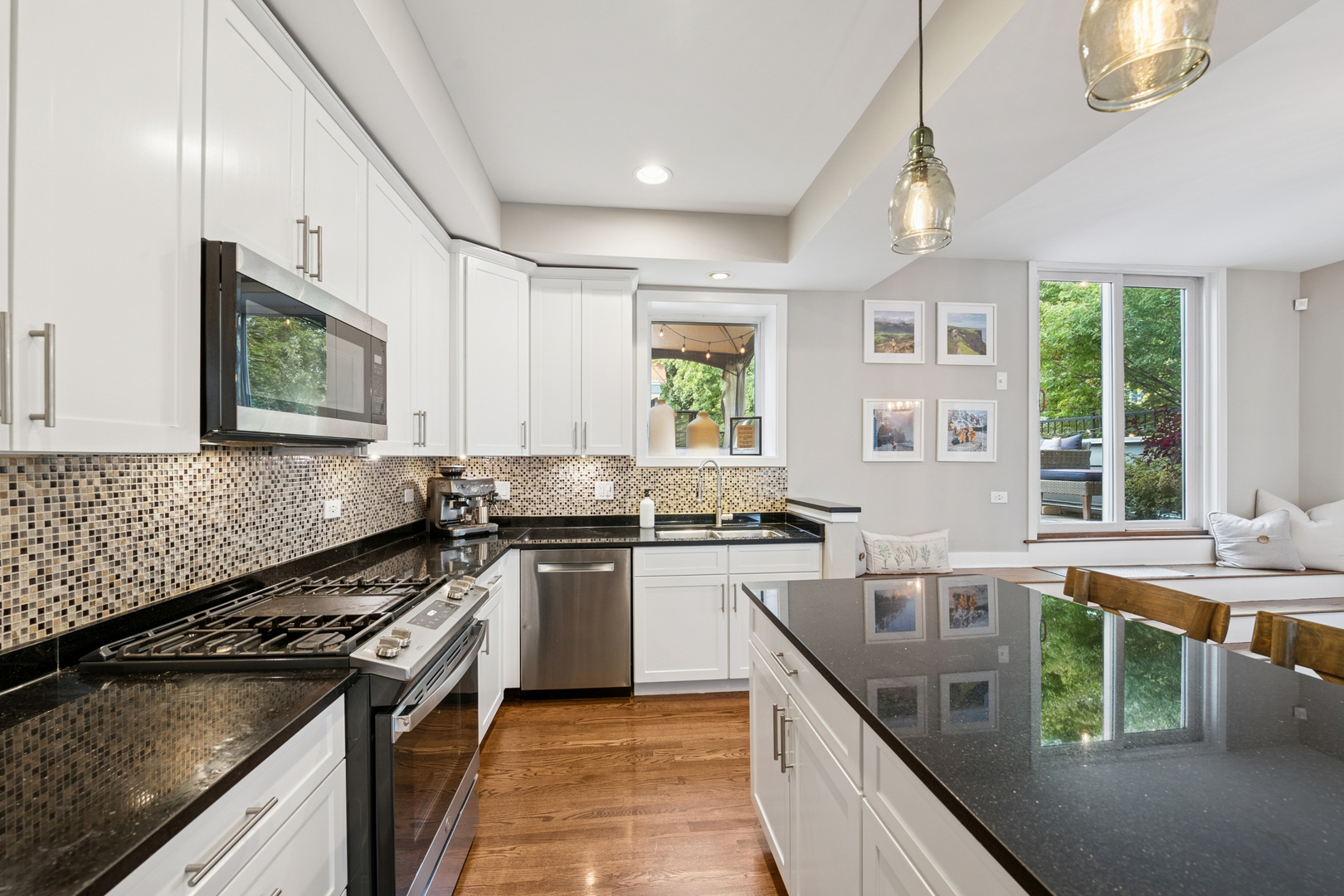 1809 West Melrose Street Chicago, IL 60657 - Photo 8 of 25 a kitchen with stainless steel appliances granite countertop a stove a sink dishwasher and a microwave oven with white cabinets