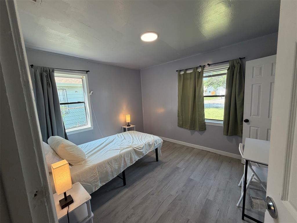 513 Shawnee Trace Grand Prairie, TX 75051 - Photo 20 of 32 Bedroom featuring two windows, wood-finish flooring, light gray walls, and recessed ceiling lighting