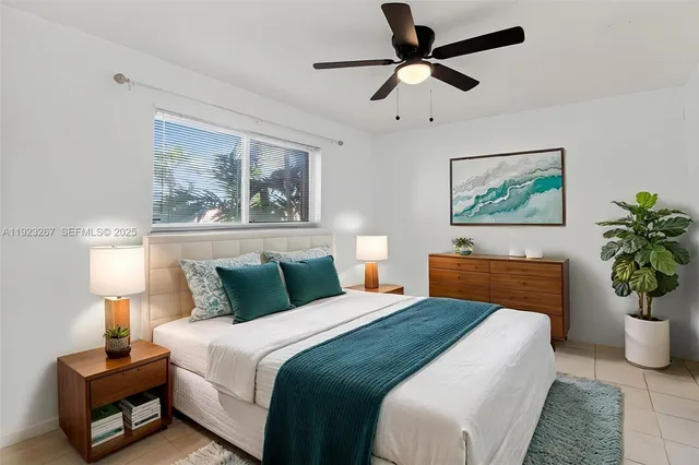a bedroom with bed painting on the wall and a potted plant