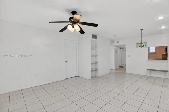 a view of a room with white walls and ceiling fan