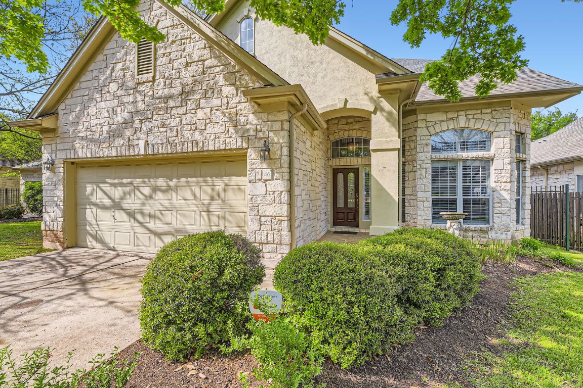 French country inspired facade featuring stucco siding, stone siding, an attached garage, and driveway