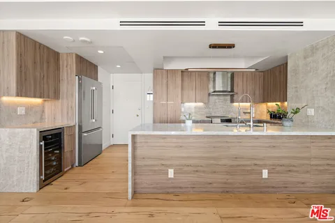 a view of kitchen with wooden cabinet and refrigerator