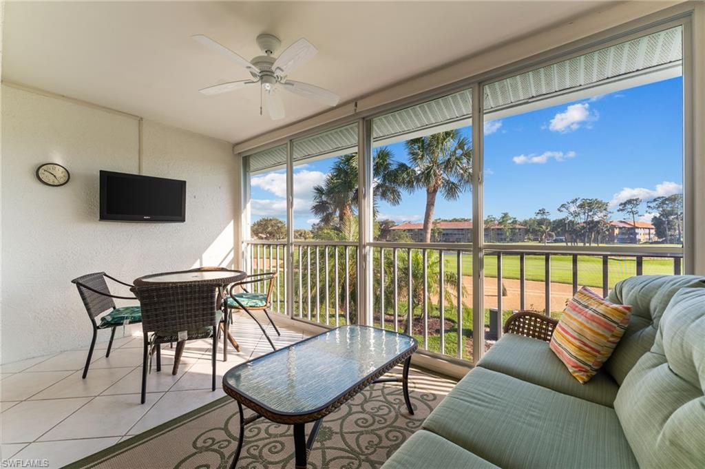 5928 Cranbrook Way, Unit D202 Naples, FL 34112 - Photo 15 of 23 Sunroom featuring tile flooring, a textured wall, a ceiling fan, and outdoor dining space