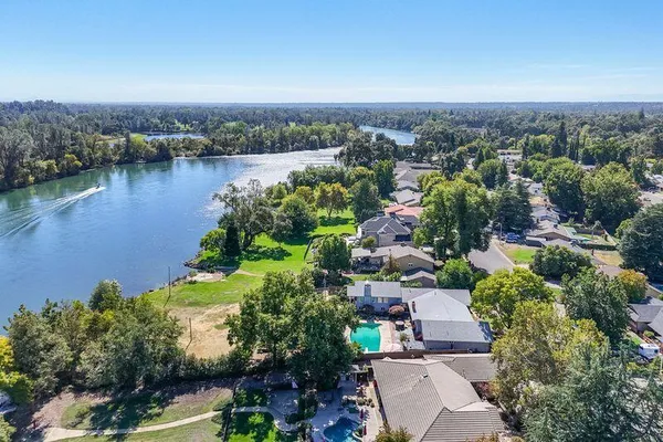 an aerial view of a house with a yard and lake view