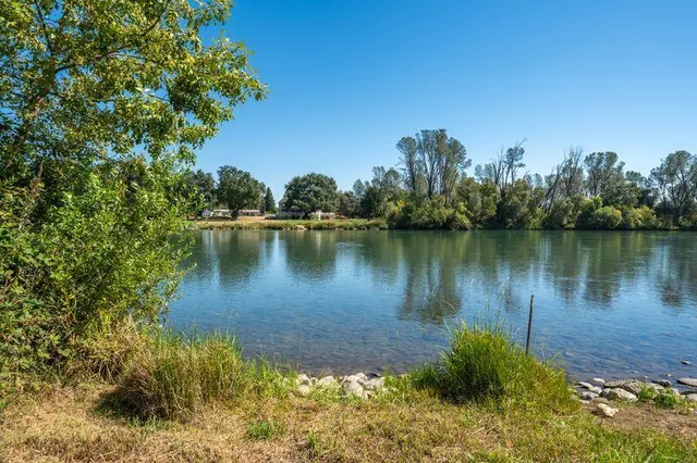 an aerial view of a house with a yard and lake view