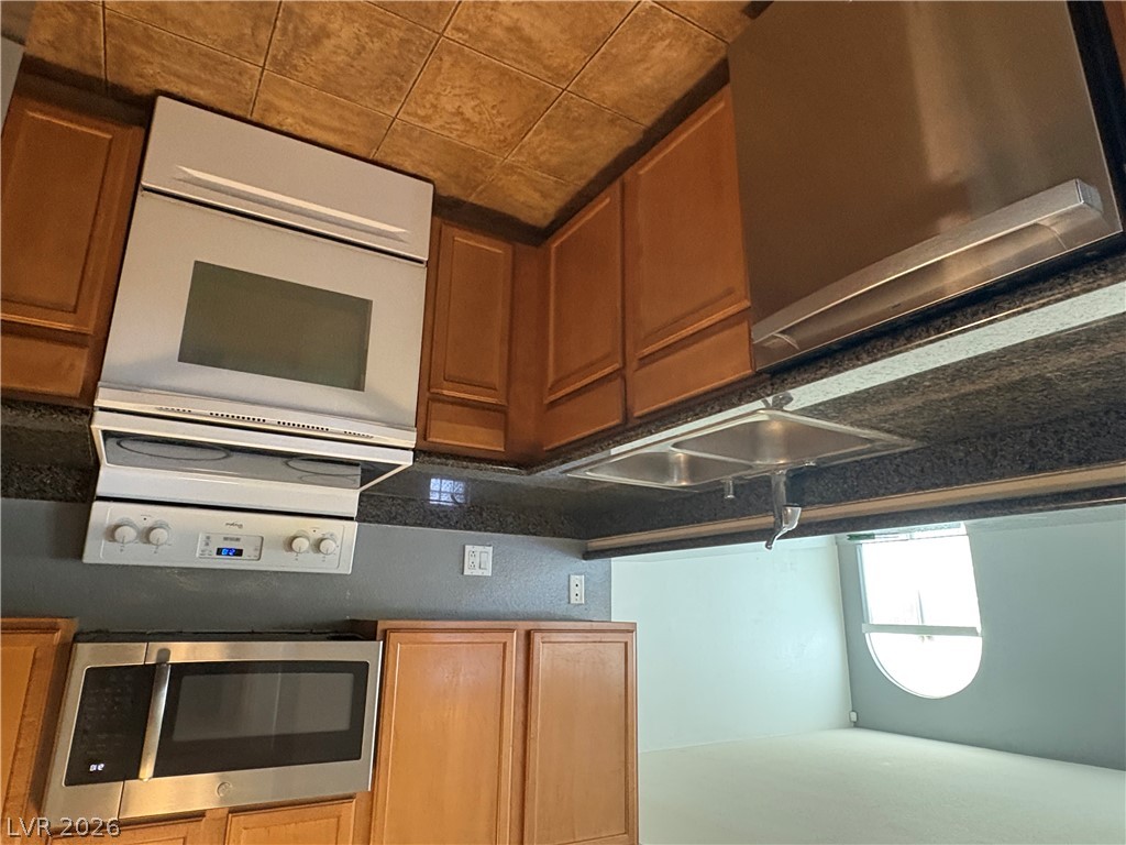 9325 West Desert Inn Road, Unit 123 Las Vegas, NV 89117 - Photo 20 of 36 A well-appointed kitchen boasts sleek stainless steel appliances, granite countertops, and warm wood cabinetry.