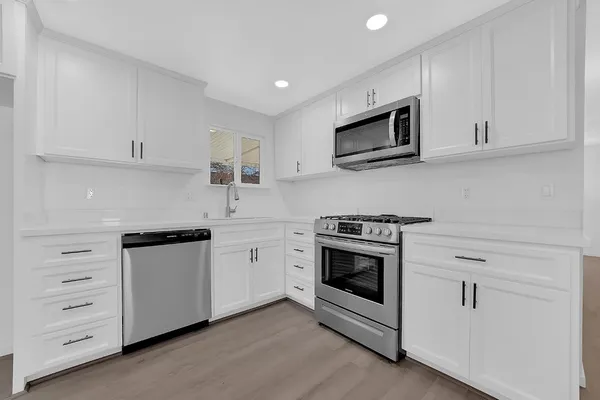 a kitchen with cabinets stainless steel appliances and sink