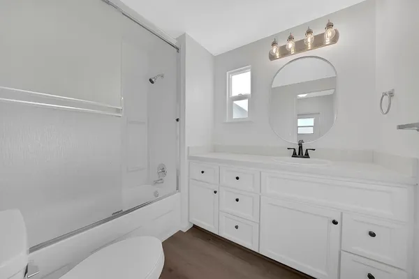 a bathroom with a bathtub sink vanity and mirror