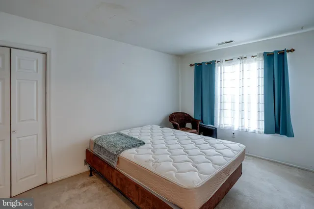 a bed sitting in a bedroom next to a window