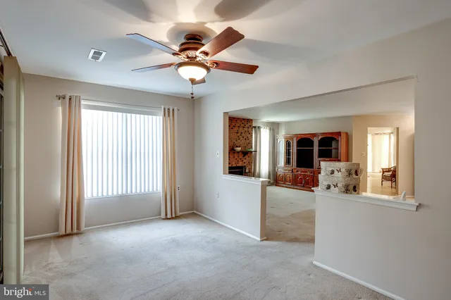 a view of a livingroom with a ceiling fan and window