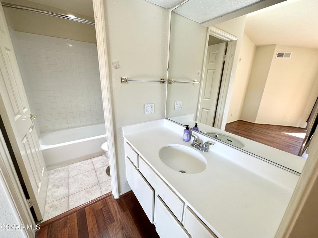 672 Indian Oak Lane, Unit 103 Oak Park, CA 91377 - Photo 20 of 34 a bathroom with a sink a mirror and a bathtub