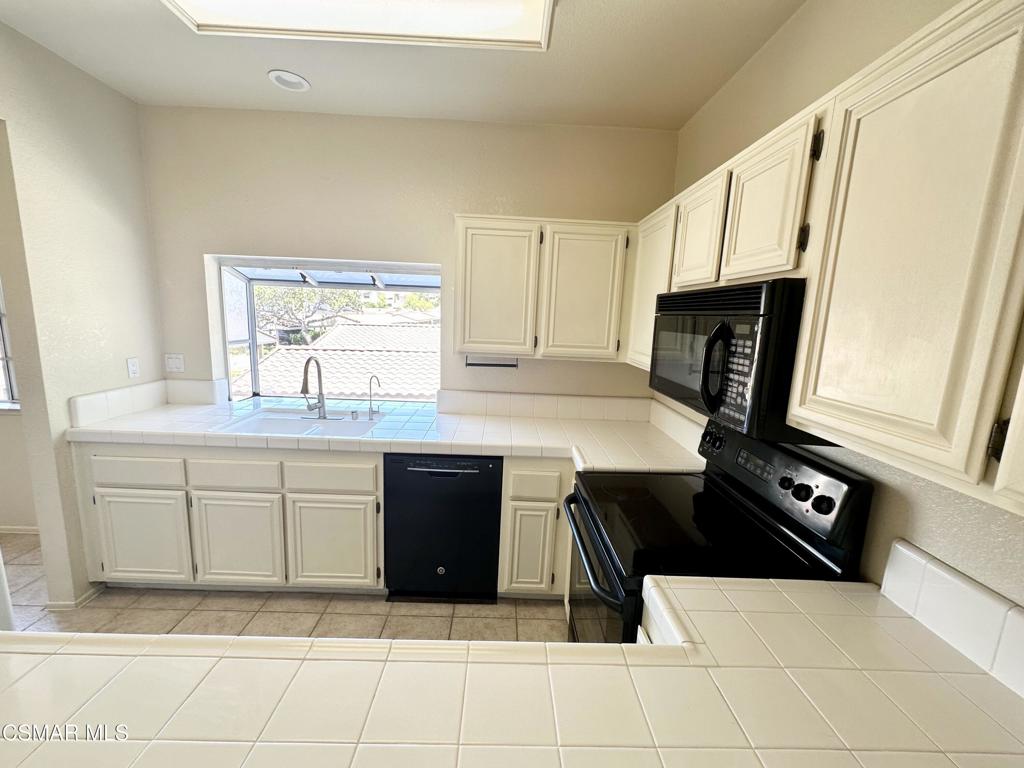 672 Indian Oak Lane, Unit 103 Oak Park, CA 91377 - Photo 3 of 34 a kitchen with stainless steel appliances a stove a sink and a microwave
