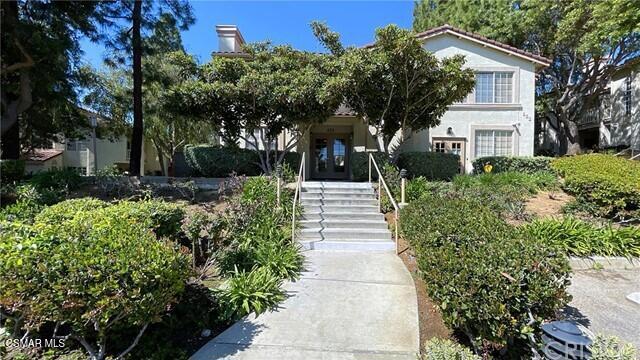 672 Indian Oak Lane, Unit 103 Oak Park, CA 91377 - Photo 32 of 34 a front view of a house with a yard