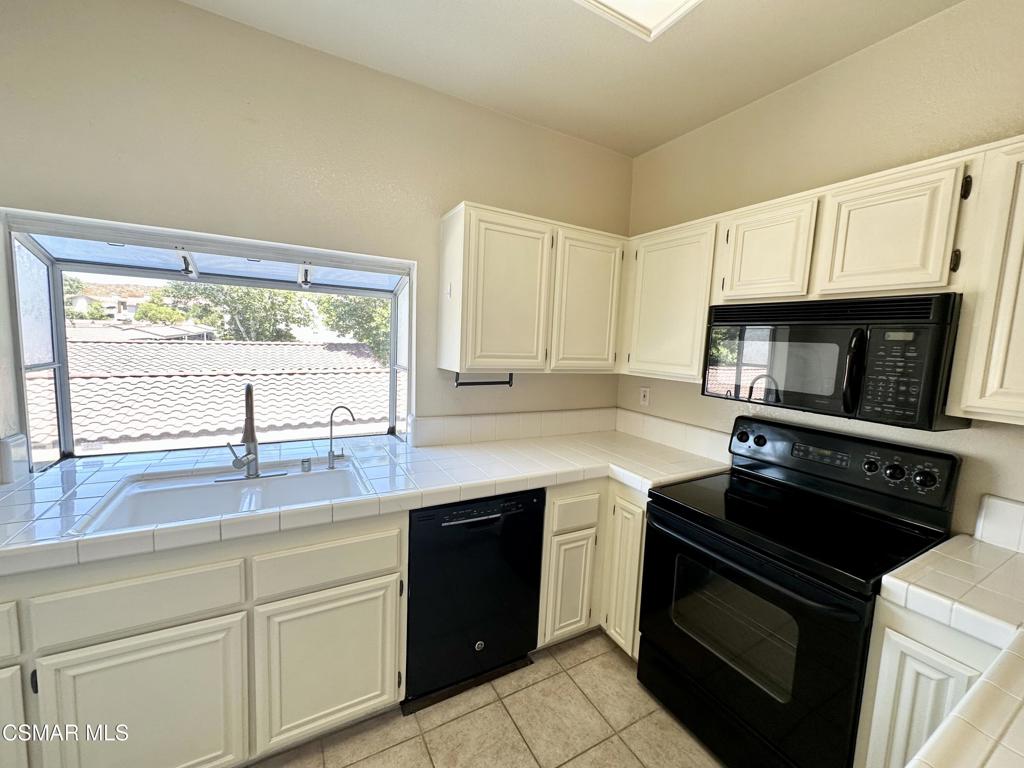 672 Indian Oak Lane, Unit 103 Oak Park, CA 91377 - Photo 4 of 34 a kitchen with granite countertop a stove sink and cabinets