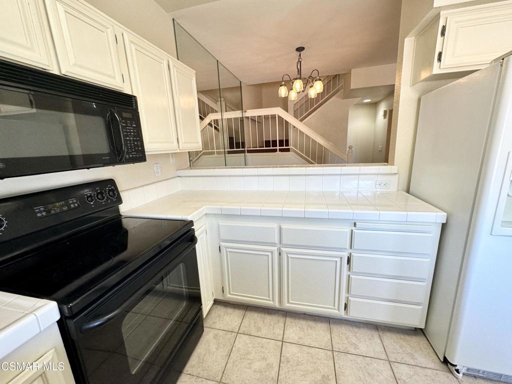 672 Indian Oak Lane, Unit 103 Oak Park, CA 91377 - Photo 5 of 34 a kitchen with a stove and a microwave