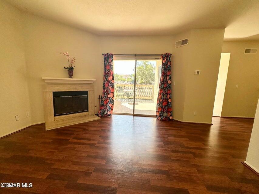672 Indian Oak Lane, Unit 103 Oak Park, CA 91377 - Photo 9 of 34 a view of an empty room with wooden floor and a fireplace