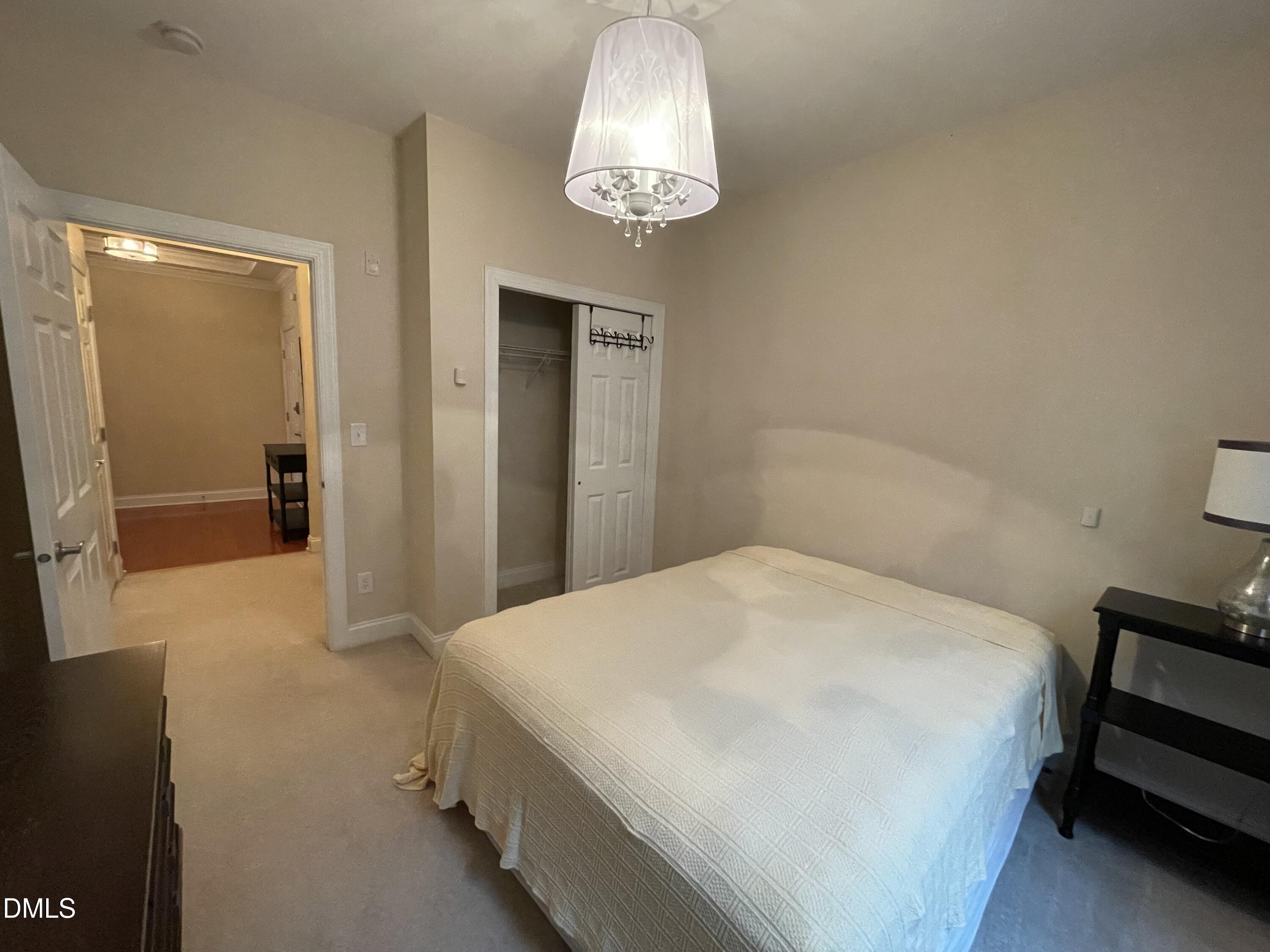 10411 Rosegate Court, Unit 3 Raleigh, NC 27617 - Photo 38 of 62 a bedroom with a bed and a chandelier