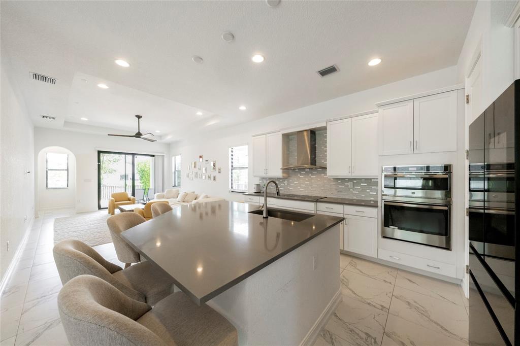 11843 Southwest 13th Court Pembroke Pines, FL 33025 - Photo 11 of 37 a large kitchen with stainless steel appliances granite countertop a sink dishwasher a stove and a refrigerator with wooden floor