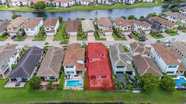an aerial view of residential houses with outdoor space and parking