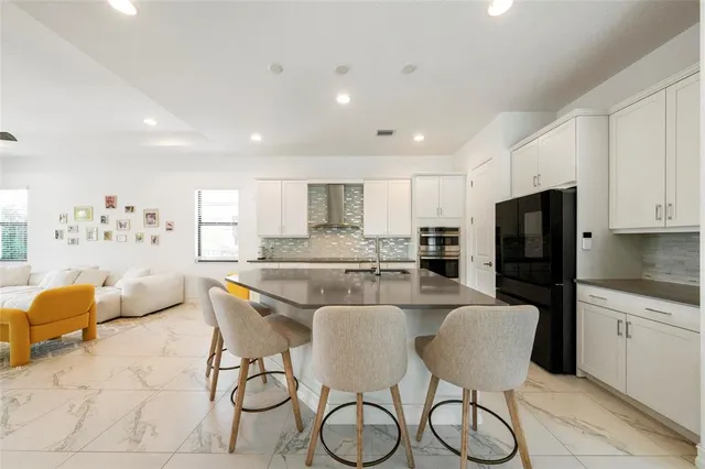 a kitchen with stainless steel appliances granite countertop a table and chairs in it