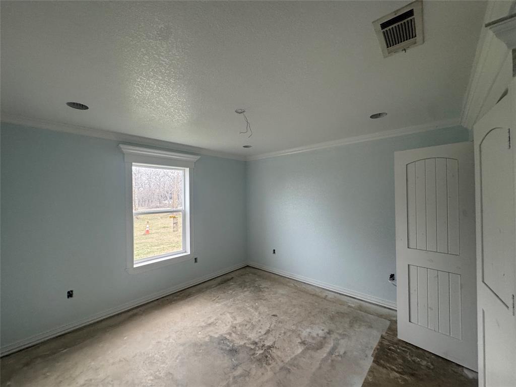 28296 Spring Valley Drive Kemp, TX 75143 - Photo 17 of 32 Empty room with ornamental molding, a textured ceiling, and concrete flooring