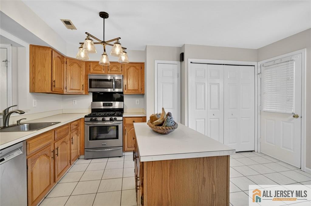 40C Rutland Lane, Unit 40B Monroe Township, NJ 08831 - Photo 10 of 37 a kitchen with stainless steel appliances a stove sink and cabinets