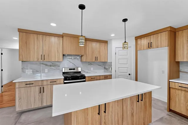 a kitchen with stainless steel appliances a sink a stove a refrigerator and cabinets