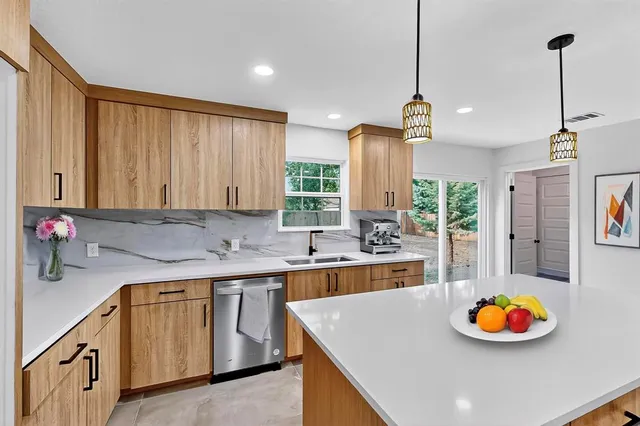 a kitchen with stainless steel appliances granite countertop a sink a stove and a wooden floors