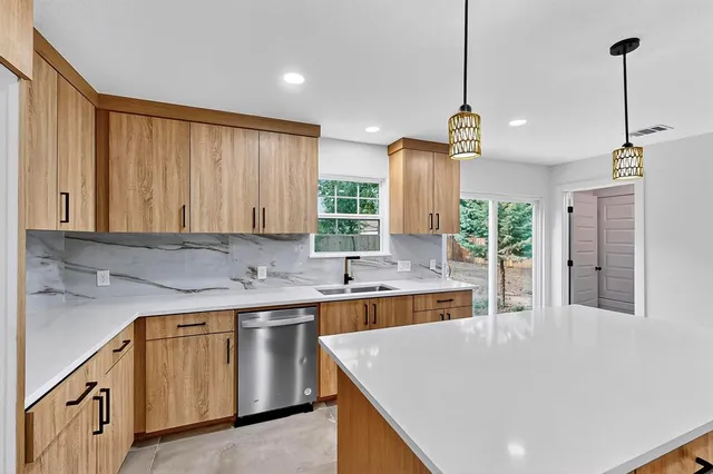 a kitchen with a sink a stove a refrigerator and cabinets