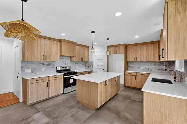 a kitchen with a sink stove top oven and cabinets