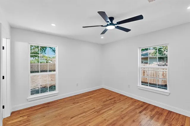 a view of a big room with wooden floor and windows