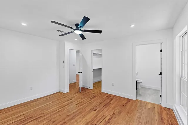 a bedroom with a bed and a ceiling fan