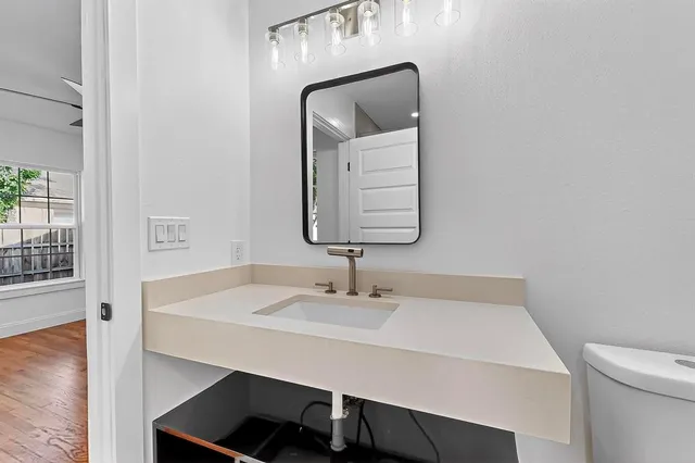 a bathroom with a sink a light fixture and a mirror