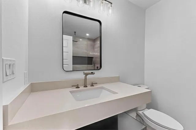 a bathroom with a sink a toilet and mirror