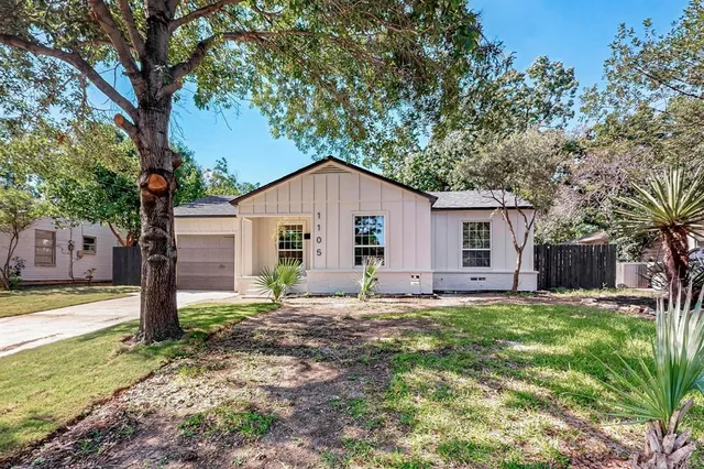 a view of a house with a yard and tree s