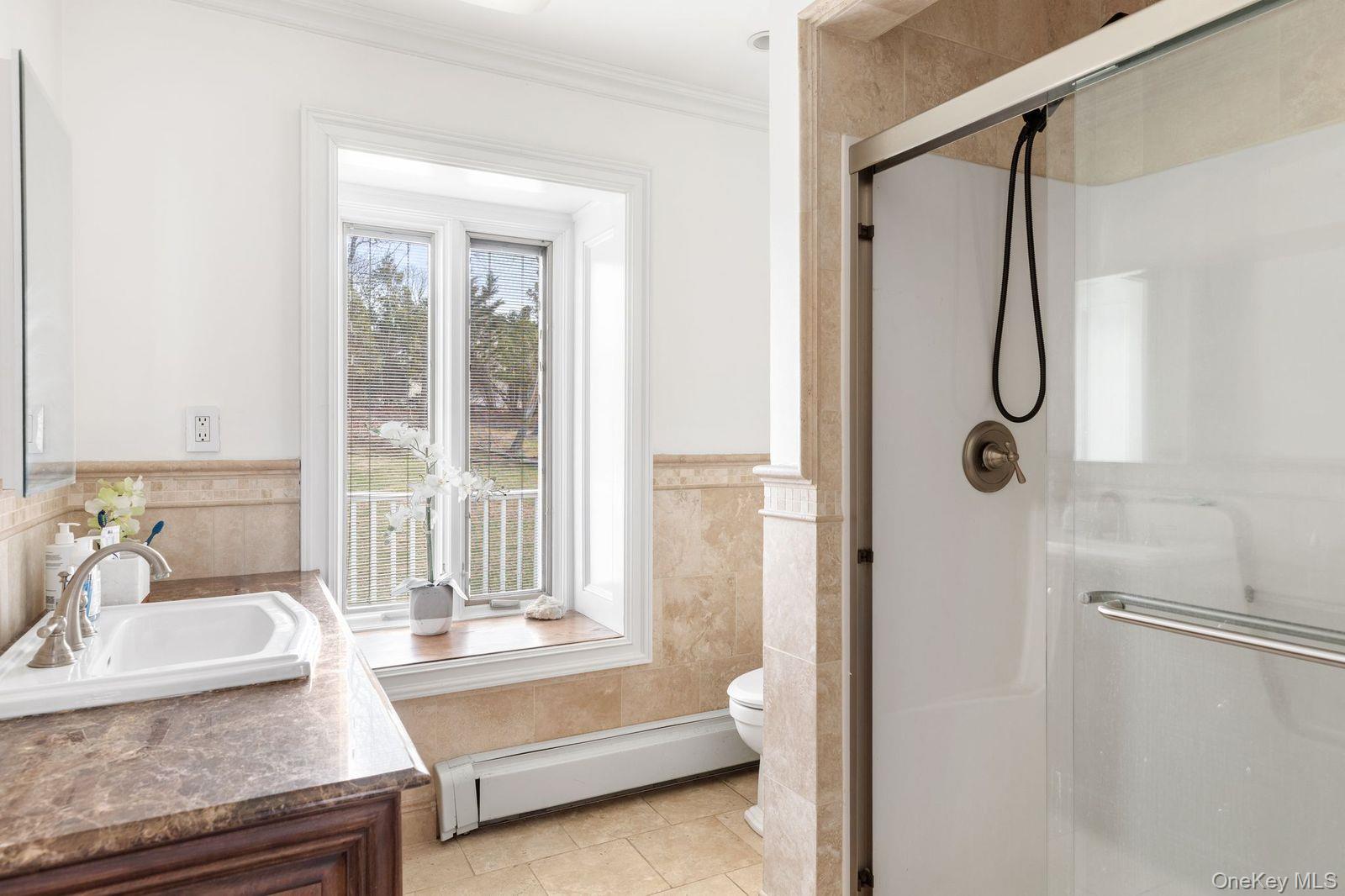 33 Beach Road Northport, NY 11768 - Photo 35 of 50 a bathroom with a granite countertop sink a mirror and shower