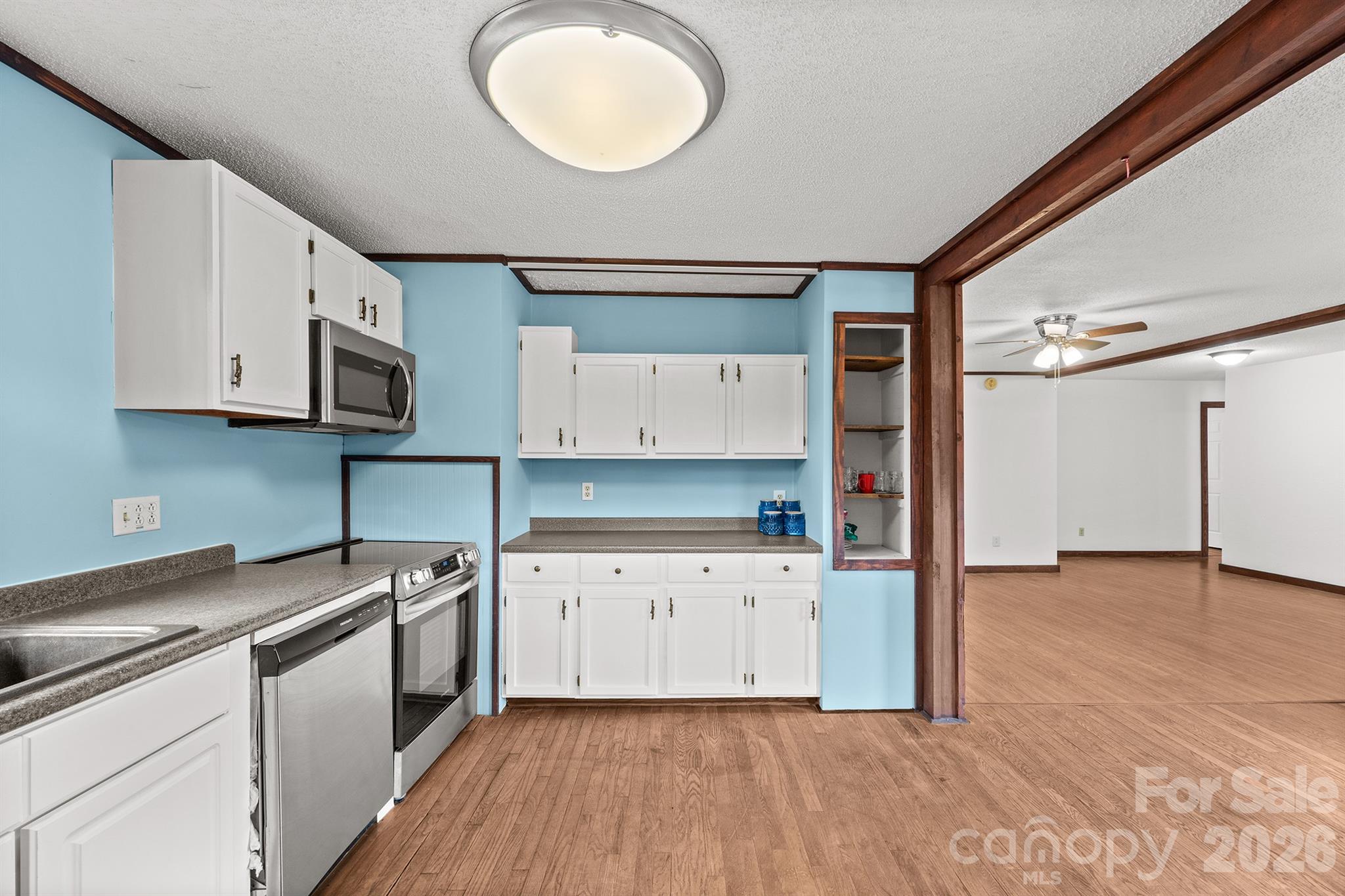 7400 Corn Hill Road Connelly Springs, NC 28612 - Photo 6 of 41 a kitchen with granite countertop a stove a sink and a white cabinets