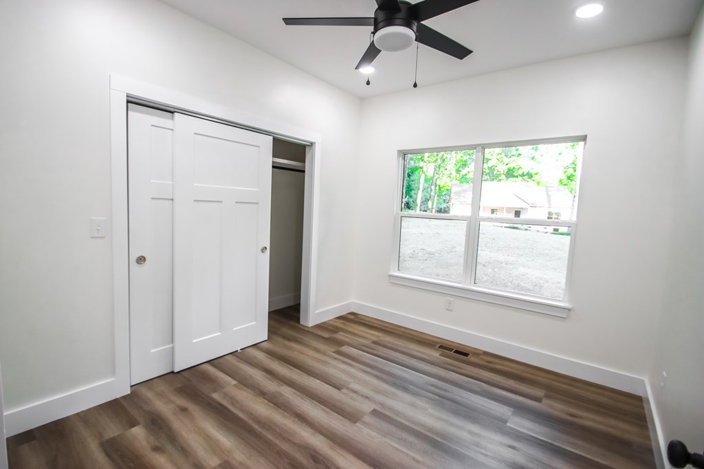 329 Webb Drive Sparta, TN 38583 - Photo 13 of 17 an empty room with wooden floor ceiling fan and windows
