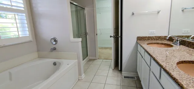 a bathroom with a granite countertop tub a sink and a mirror