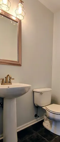 a bathroom with a toilet a sink and mirror